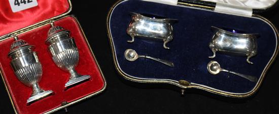 A cased pair of silver salts and a cased pair of silver pepperettes.